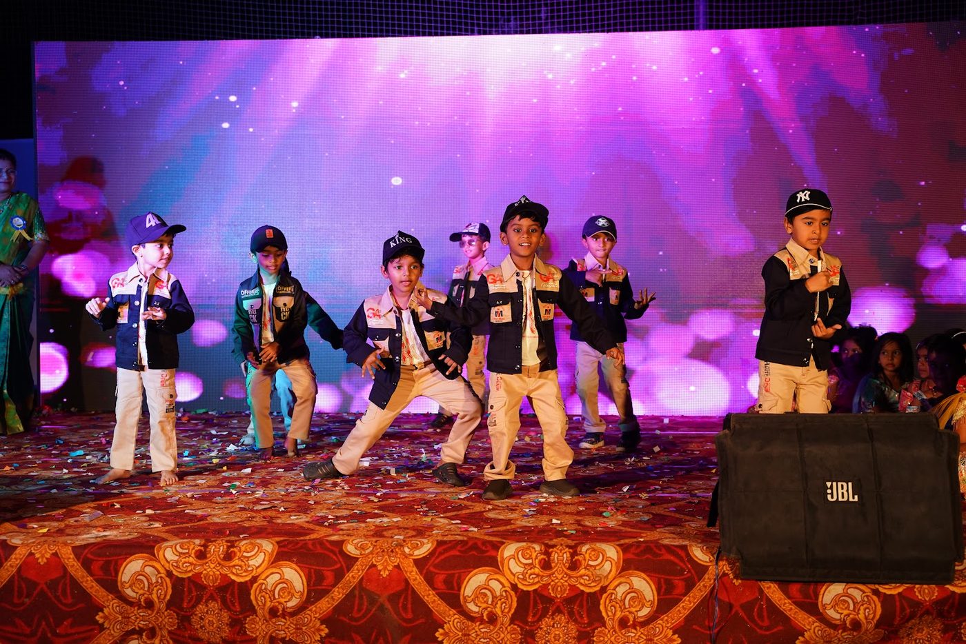 A troupe of Little Ville students performing a group dance on stage at Annual Day