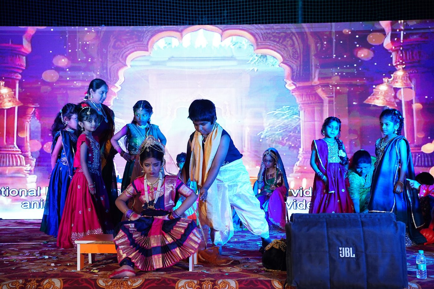 Students performing a dance drama in traditional costume at Little Ville Annual Day