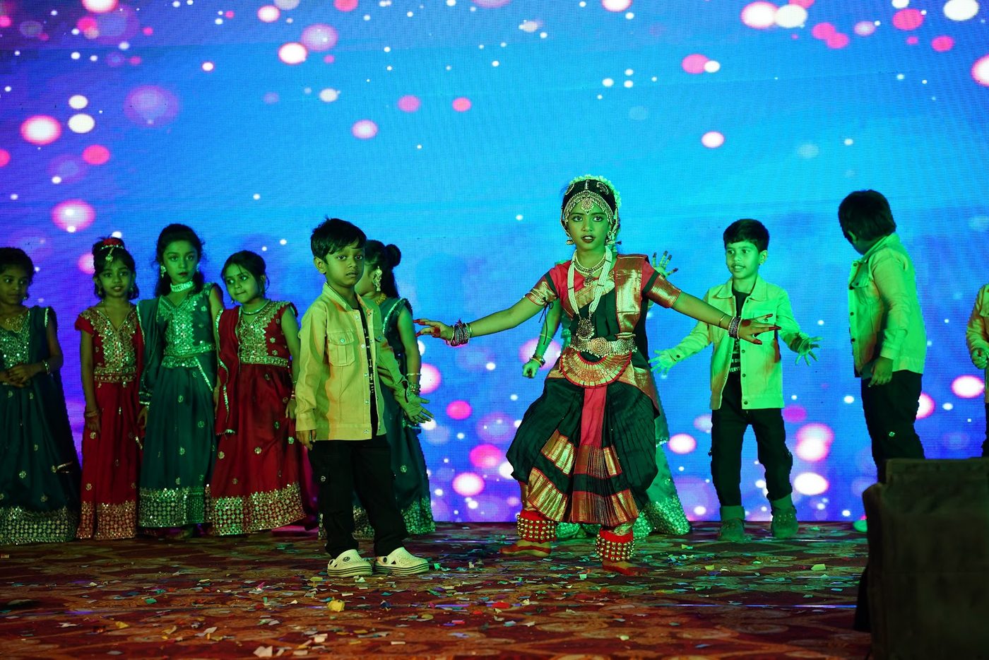 A Little Ville student performing a dance solo on stage at Annual Day