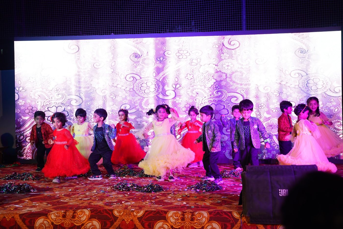 Little Ville students in formal dress performing a group dance at Annual Day