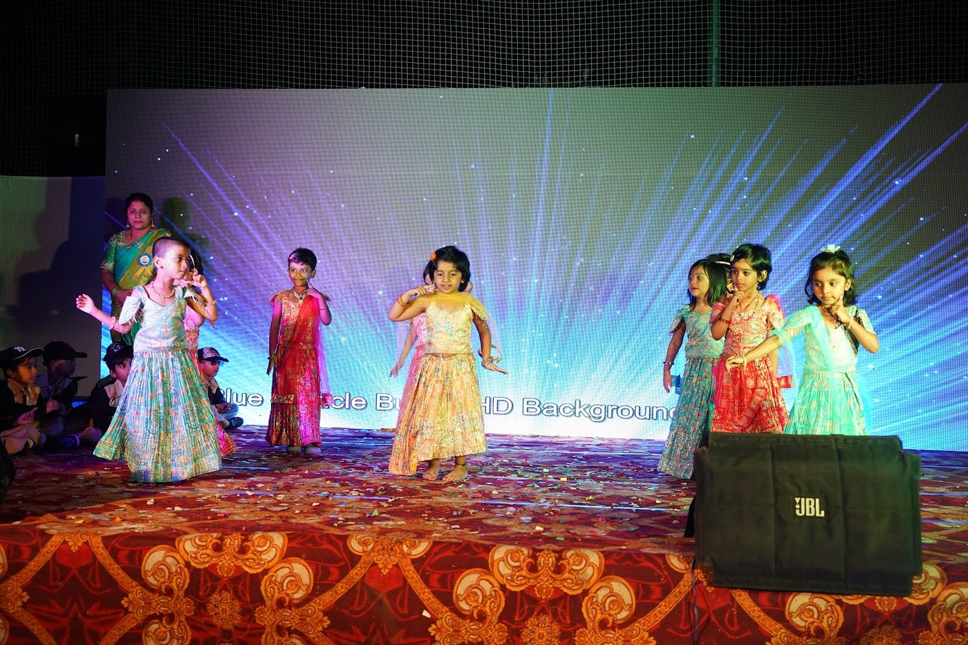 Little Ville students singing into microphones on stage at Annual Day 2025-26