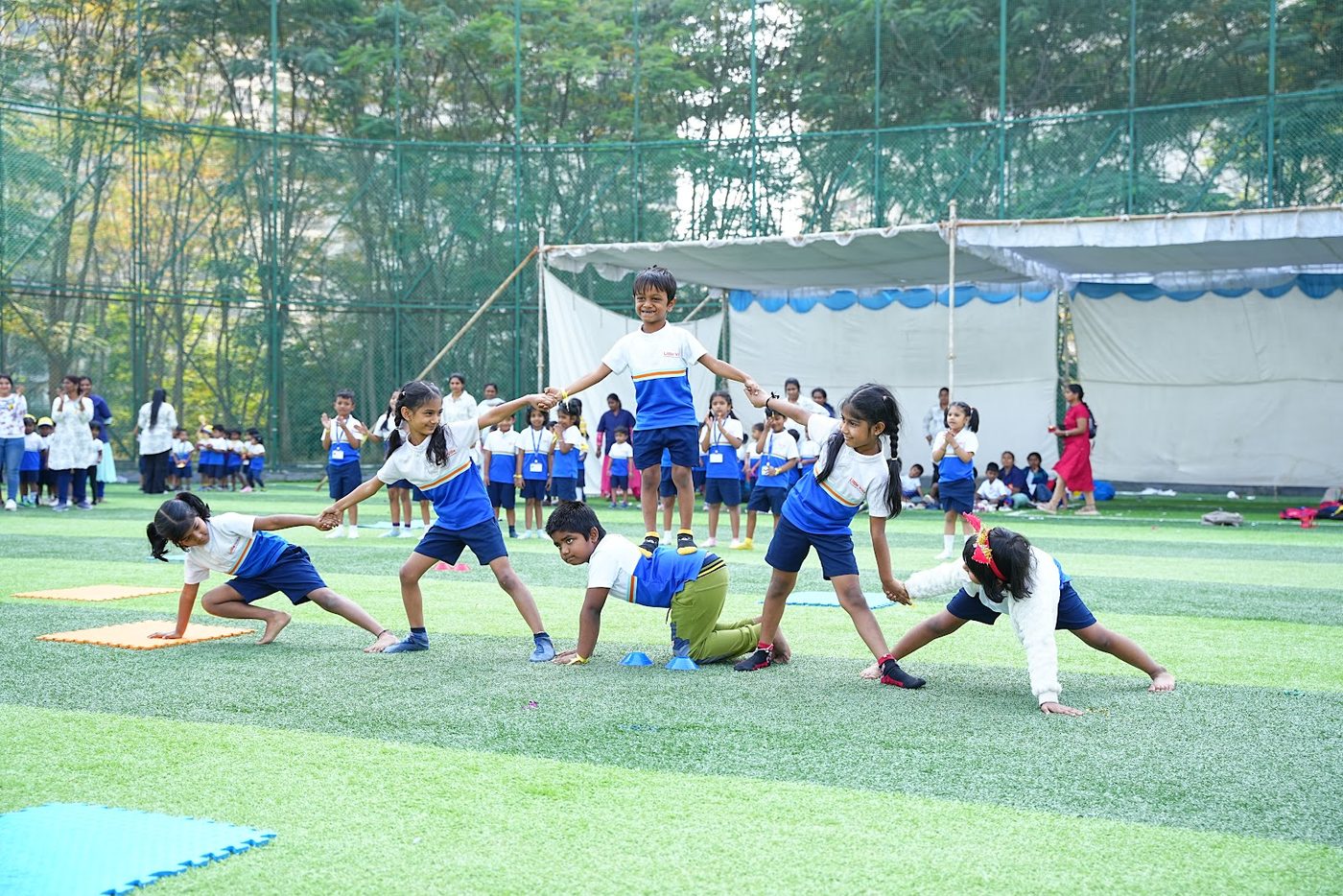 Little Ville students stretching together on the field before their Khel Utsav events